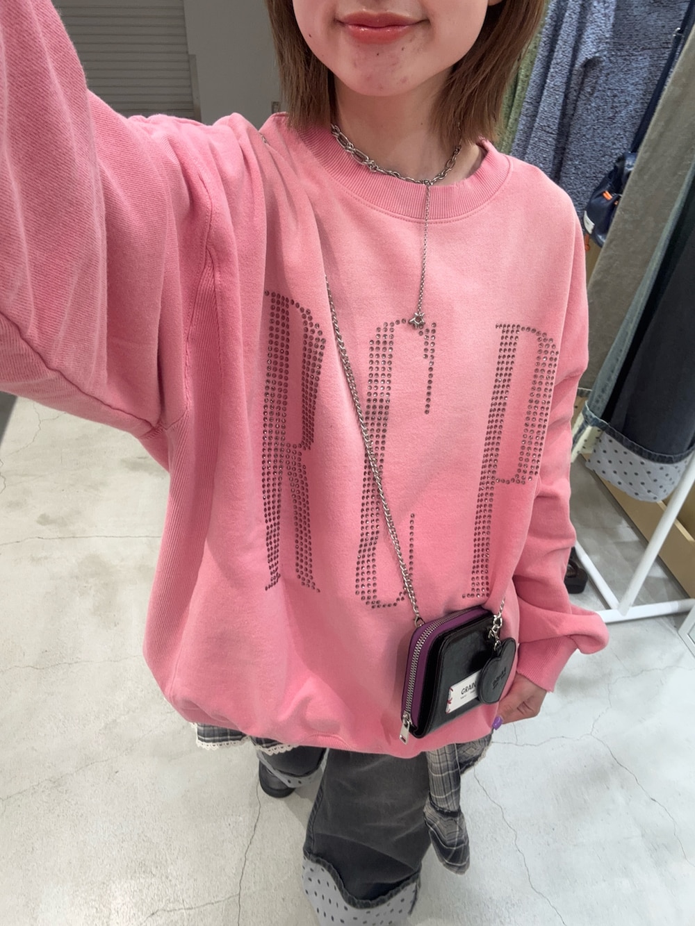 ピンク系のパーカー、ブラック系のデニムパンツ、ブラック系のその他シューズを着用したレディースの春コーディネートの2枚目の写真