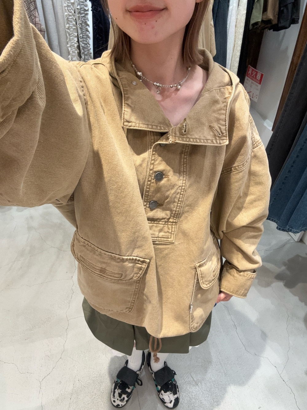 ベージュ系のブルゾン、グリーン系のスカート、ホワイト系のその他パンツを着用したレディースの秋コーディネートの2枚目の写真