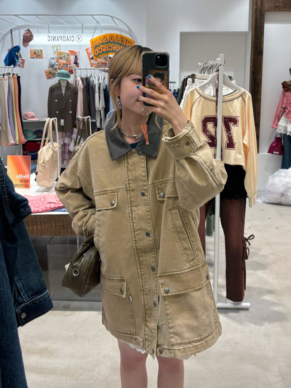 ベージュ系のブルゾン、ホワイト系のその他パンツ、ブラウン系のショルダーバッグを着用したレディースの秋コーディネートの2枚目の写真