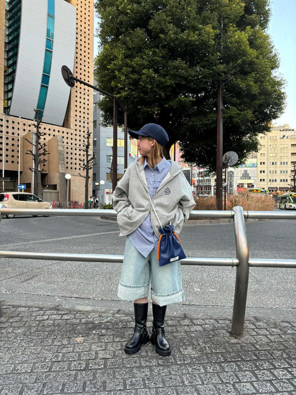 グレー系のトップス、ブルー系のトップス、ブルー系のショルダーバッグを着用したレディースの冬コーディネートの2枚目の写真