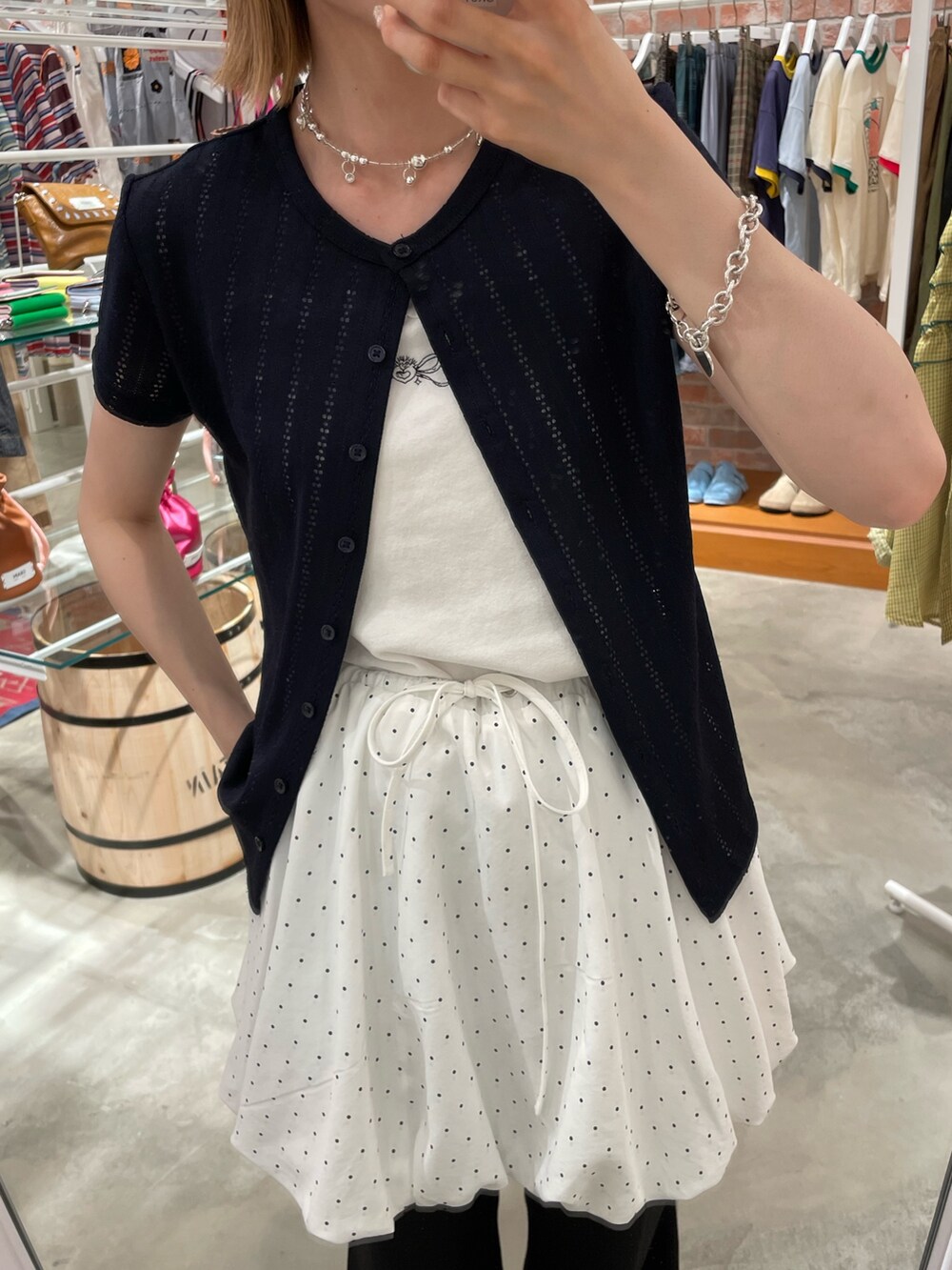 ホワイト系のスカート、ブラック系のその他パンツ、ホワイト系のキャミソールを着用したレディースの夏コーディネートの2枚目の写真