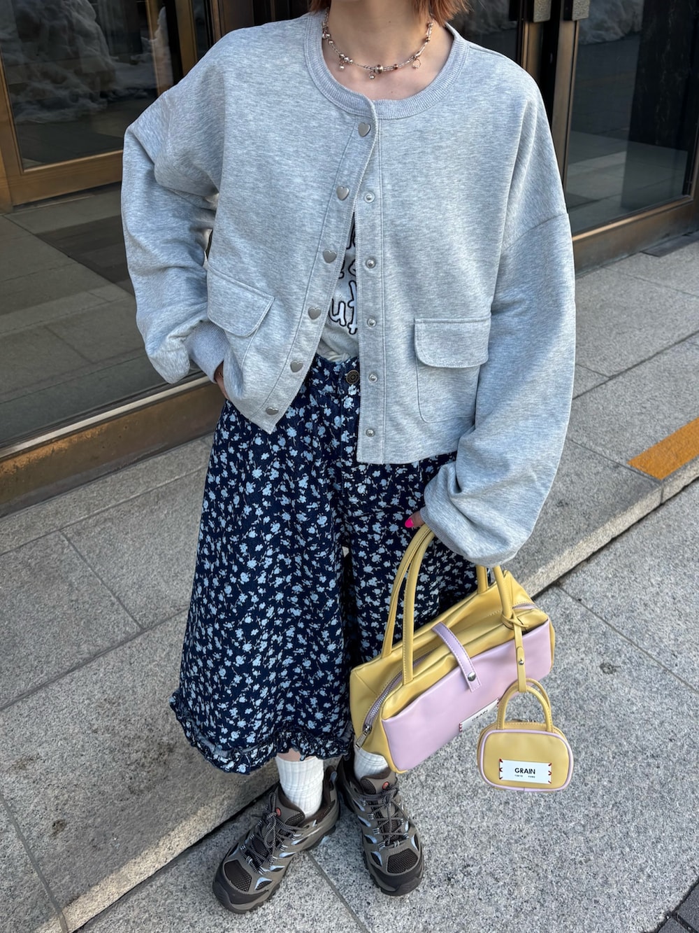 グレー系のTシャツ/カットソー、ブルー系のデニムパンツ、イエロー系のトートバッグを着用したレディースの冬コーディネートの2枚目の写真