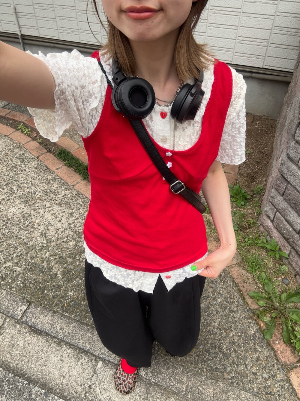 レッド系のキャミソール、ホワイト系のシャツ/ブラウス、ブラック系のスラックスを着用したレディースの夏コーディネートの3枚目の写真