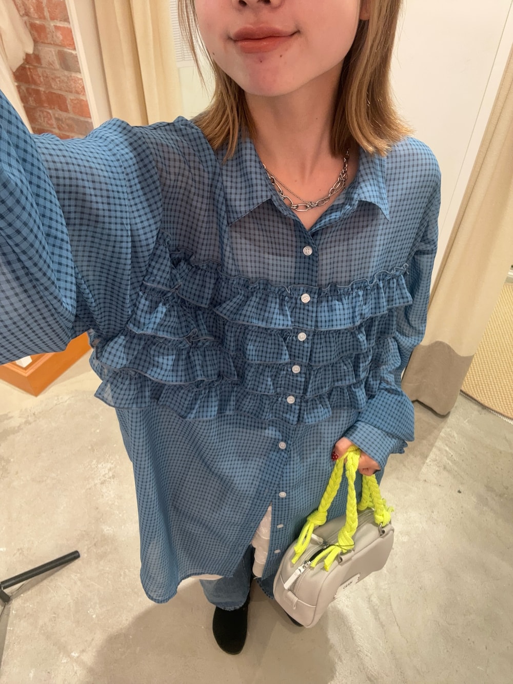 ブルー系のシャツ/ブラウス、グレー系のハンドバッグを着用したレディースの春コーディネートの2枚目の写真