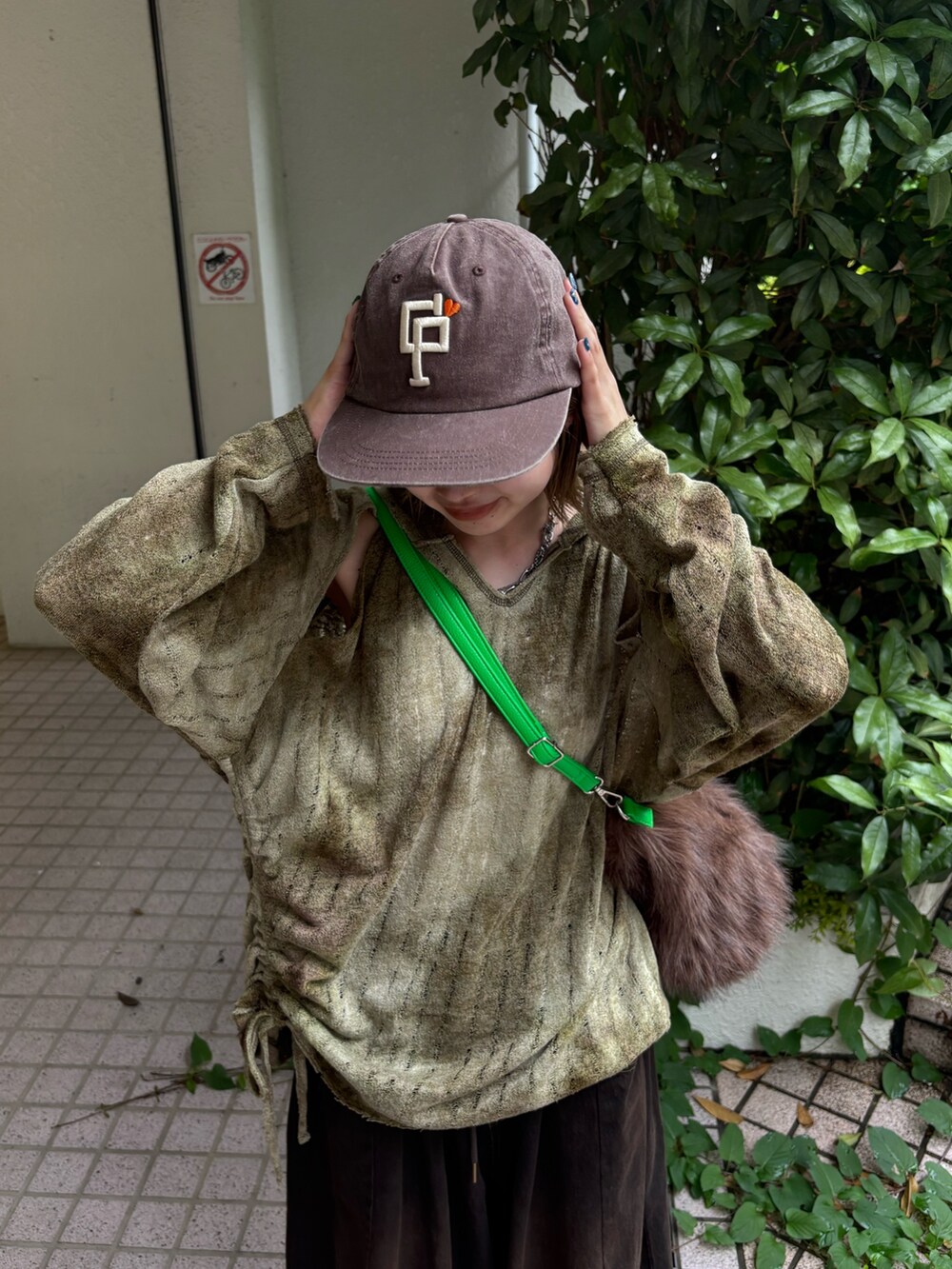 グリーン系のTシャツ/カットソー、ブラウン系のデニムパンツ、シルバー系のサンダルを着用したレディースの夏コーディネートの2枚目の写真