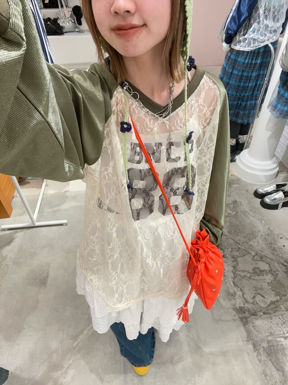 グリーン系のTシャツ/カットソー、レッド系のショルダーバッグ、ホワイト系のスカートを着用したレディースの春コーディネートの2枚目の写真