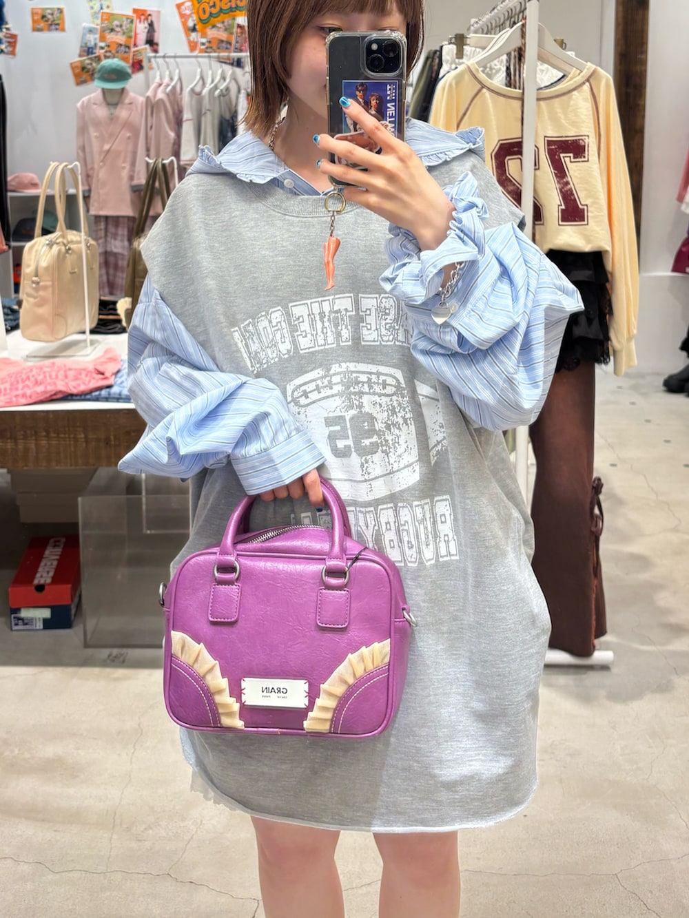グレー系のTシャツ/カットソー、ブルー系のシャツ/ブラウス、パープル系のショルダーバッグを着用したレディースの秋コーディネートの2枚目の写真