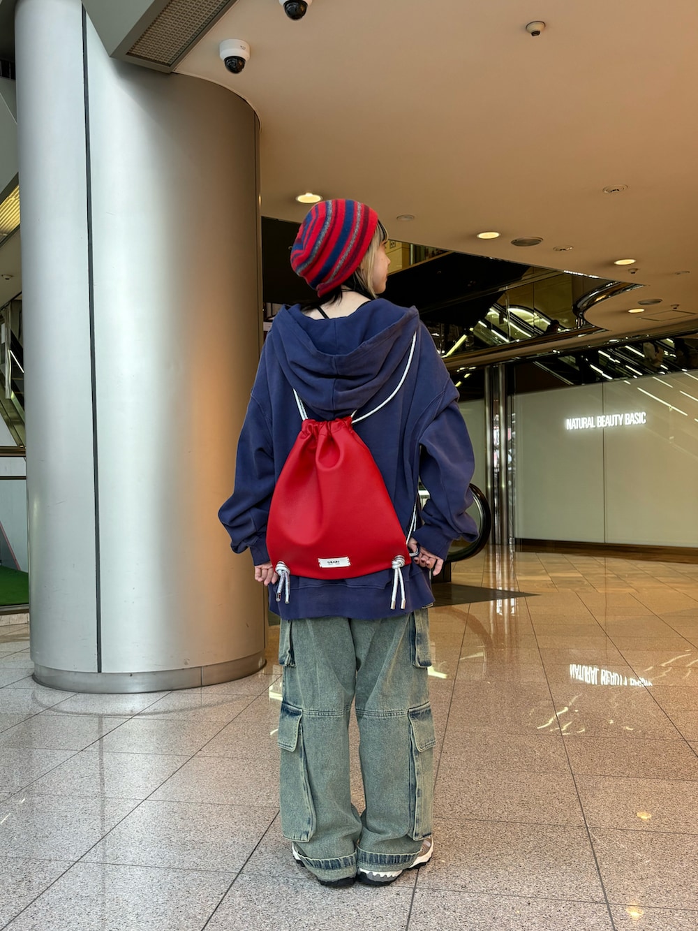 ブラック系のパーカー、ブラック系のTシャツ/カットソー、レッド系のバックパック/リュックを着用したレディースの秋コーディネートの3枚目の写真