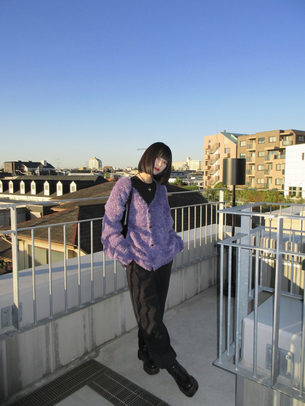 ブラック系のスウェットパンツ、ブラック系のブーツ、ブラック系のショルダーバッグを着用したレディースの秋コーディネートの3枚目の写真