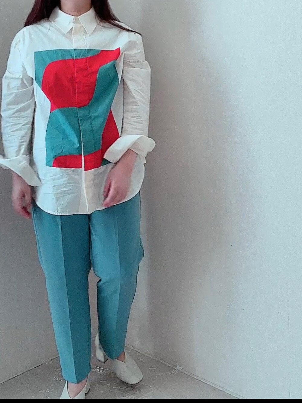 オレンジ系のシャツ/ブラウス、ブラック系のその他パンツ、ホワイト系のパンプスを着用したレディースの春コーディネートの2枚目の写真