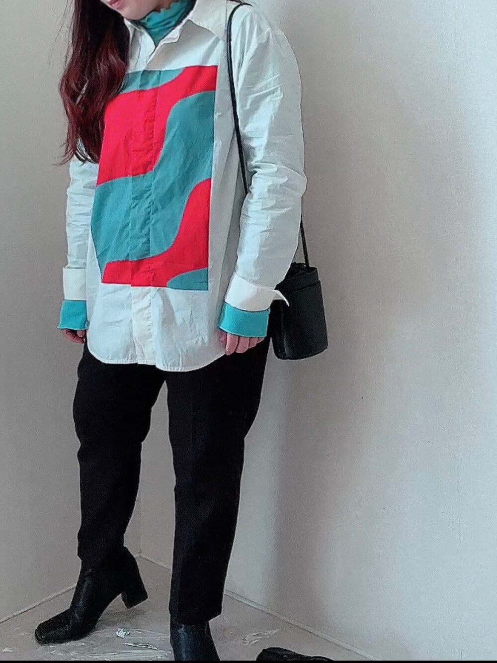 オレンジ系のシャツ/ブラウス、ブラック系のショルダーバッグ、ブラック系のその他パンツを着用したレディースの春コーディネートの3枚目の写真