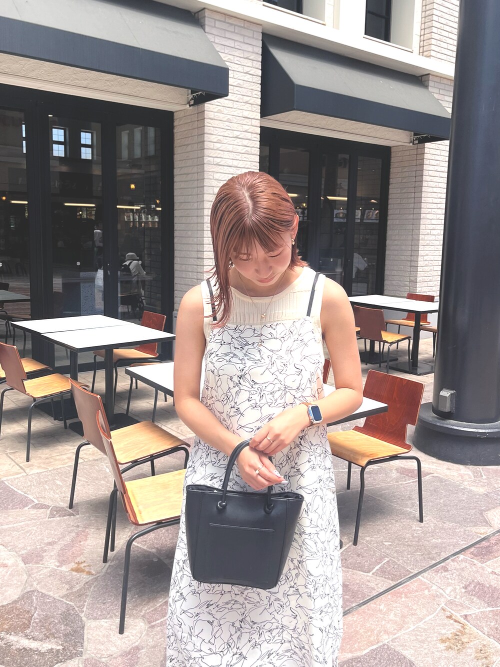 ホワイト系のワンピース、ブラック系のサンダルを着用したレディースの春コーディネートの3枚目の写真