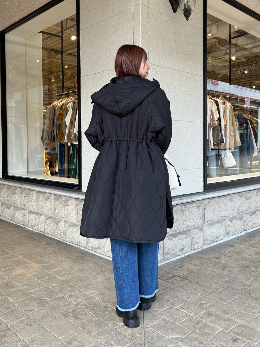 ブラック系のその他アウター、グレー系のニット/セーター、ホワイト系のショルダーバッグを着用したレディースの秋コーディネートの2枚目の写真