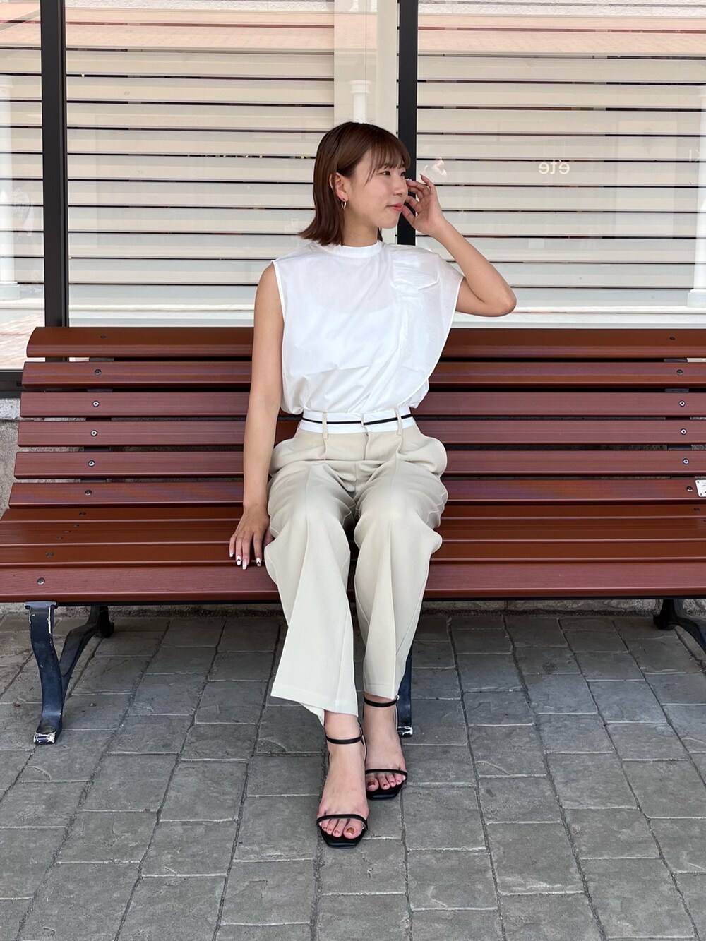 ベージュ系のパンツ、イエロー系のショルダーバッグ、ブラック系のシューズを着用したレディースの夏コーディネートの3枚目の写真