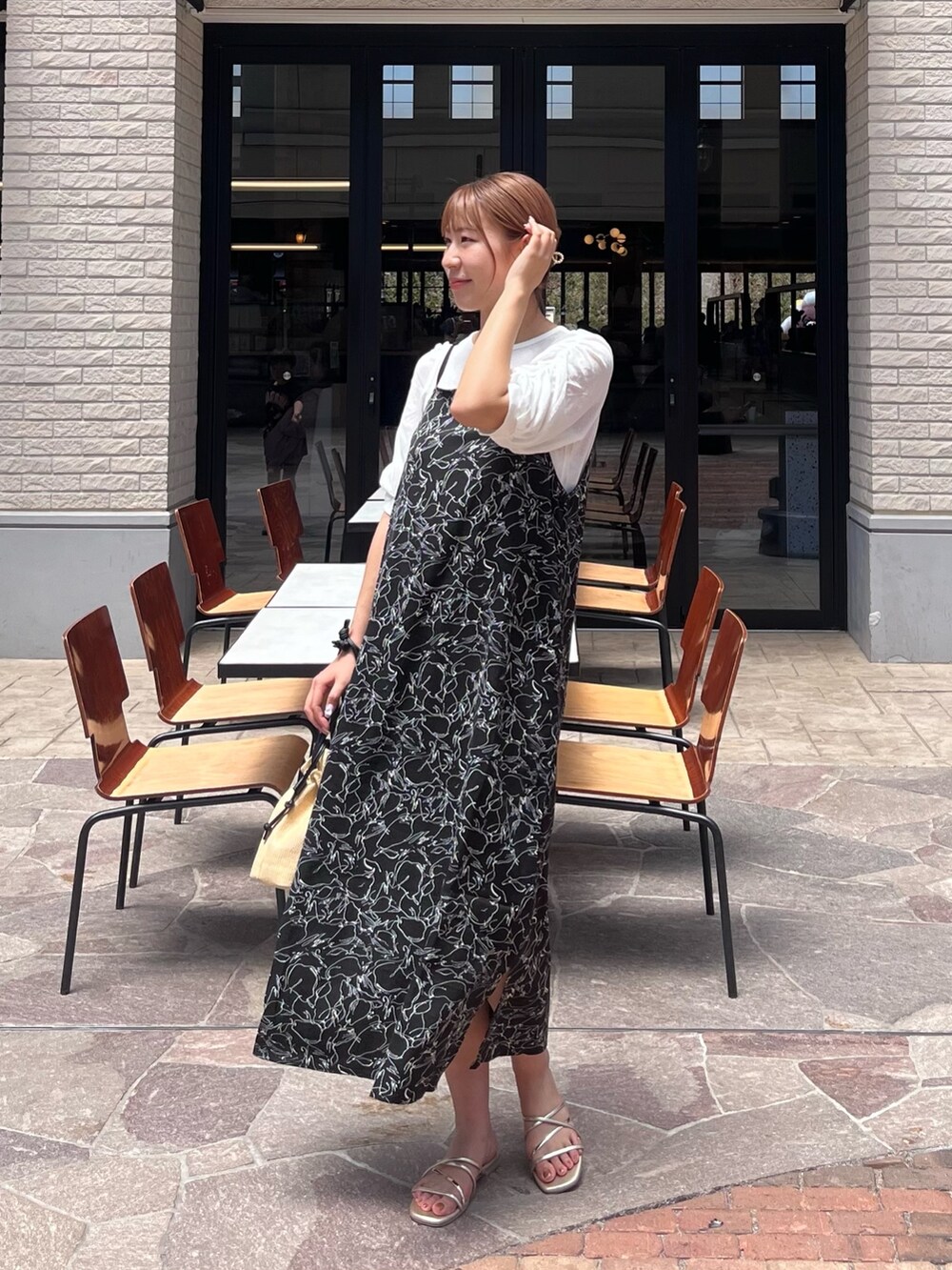 ホワイト系のTシャツ/カットソー、ブラック系のワンピース、ベージュ系のショルダーバッグを着用したレディースの夏コーディネートの2枚目の写真