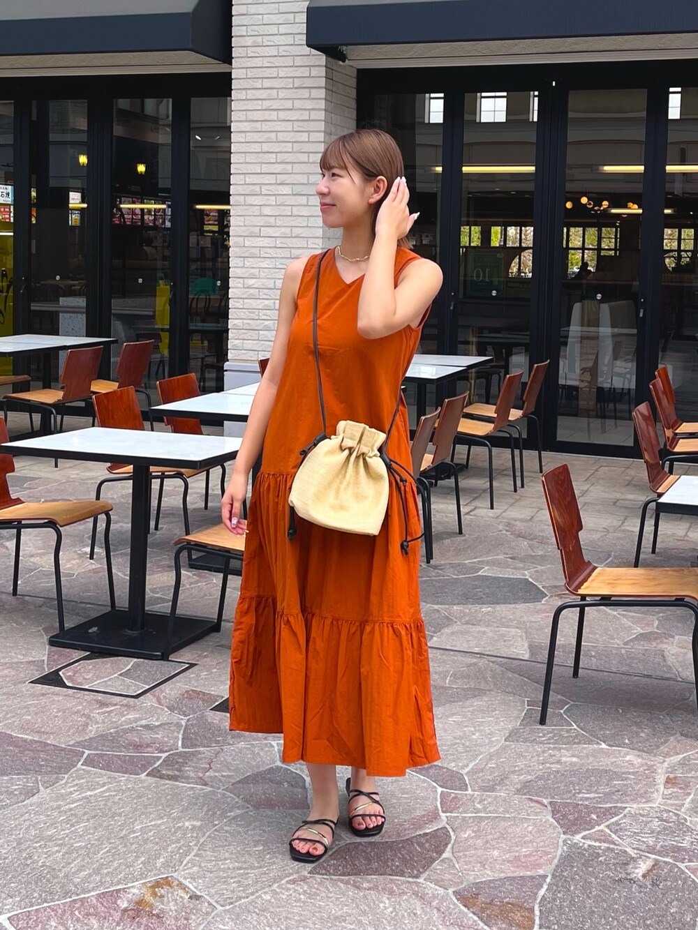 ホワイト系のシャツ/ブラウス、ブラック系のサンダル、オレンジ系のワンピースを着用したレディースの夏コーディネートの3枚目の写真