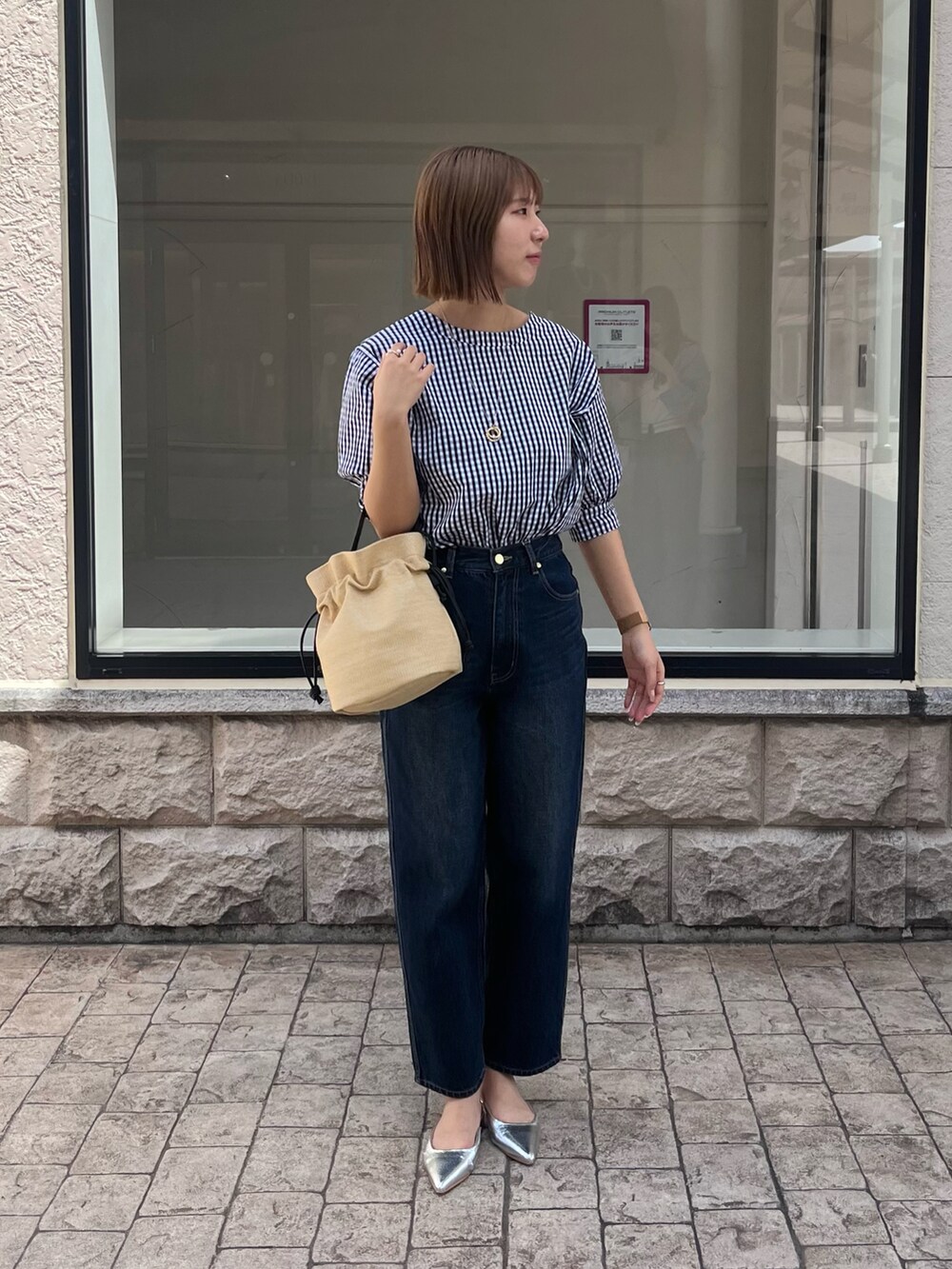 その他のトップス、ベージュ系のトートバッグ、ブルー系のデニムパンツを着用したレディースの春コーディネートの2枚目の写真