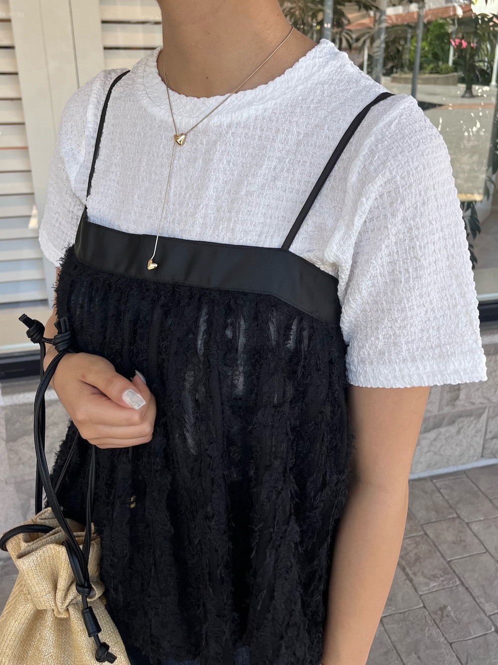 ホワイト系のTシャツ/カットソー、ブルー系のデニムパンツ、ベージュ系のショルダーバッグを着用したレディースの夏コーディネートの3枚目の写真