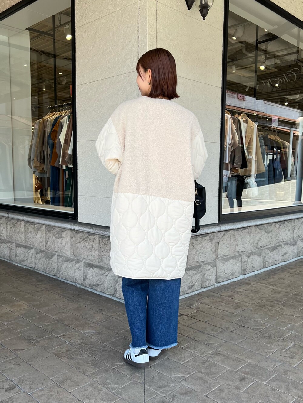 ホワイト系のその他アウター、ホワイト系のTシャツ/カットソー、ブルー系のデニムパンツを着用したレディースの秋コーディネートの2枚目の写真