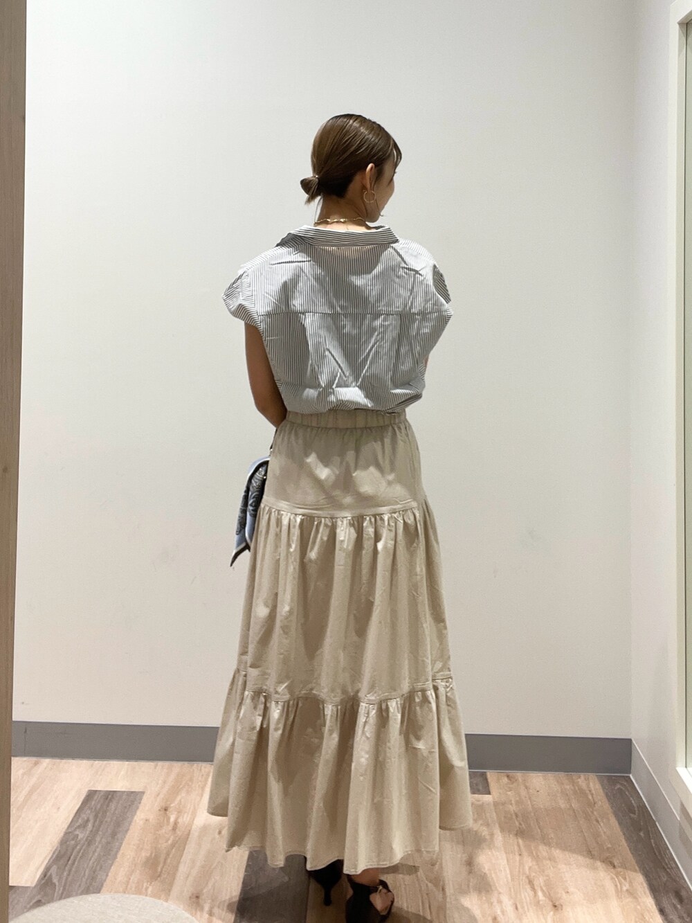 ホワイト系のシャツ/ブラウス、ブラック系のショルダーバッグ、ベージュ系のスカートを着用したレディースの夏コーディネートの3枚目の写真