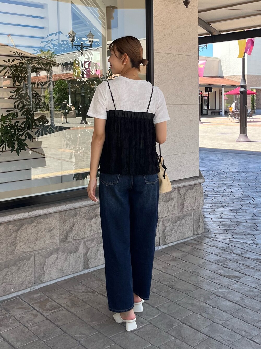 ホワイト系のTシャツ/カットソー、ブルー系のデニムパンツ、ベージュ系のショルダーバッグを着用したレディースの夏コーディネートの2枚目の写真