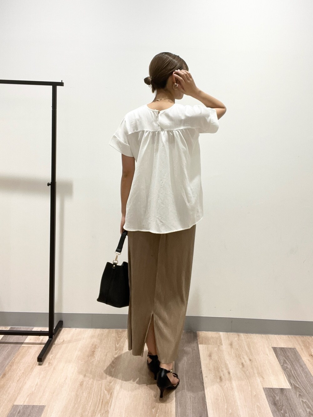 ホワイト系のシャツ/ブラウス、ベージュ系のスカート、ブラック系のショルダーバッグを着用したレディースの夏コーディネートの3枚目の写真