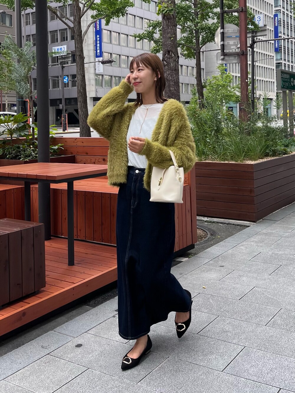 グリーン系のカーディガン/ボレロ、ホワイト系のTシャツ/カットソー、ブルー系のスカートを着用したレディースの夏コーディネートの3枚目の写真