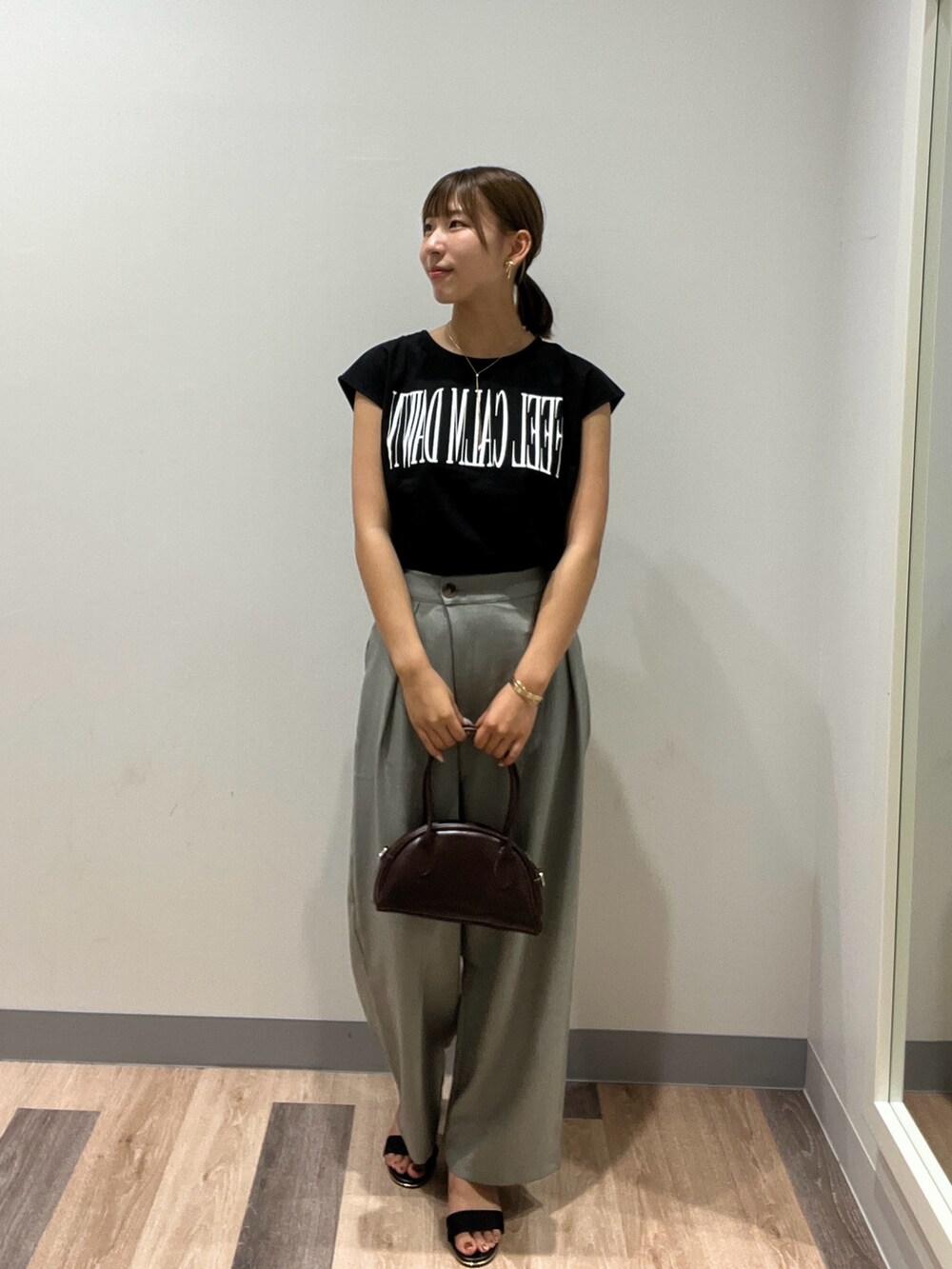 ブラック系のTシャツ/カットソー、グリーン系のその他パンツ、レッド系のトートバッグを着用したレディースの夏コーディネートの2枚目の写真