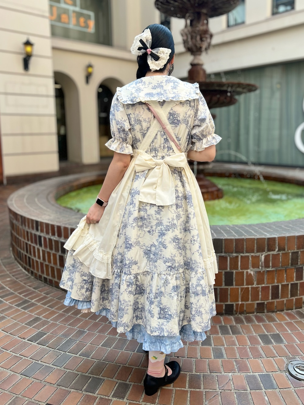 ホワイト系のワンピース、ブルー系のスカート、ブラック系のパンプスを着用したレディースの秋コーディネートの2枚目の写真