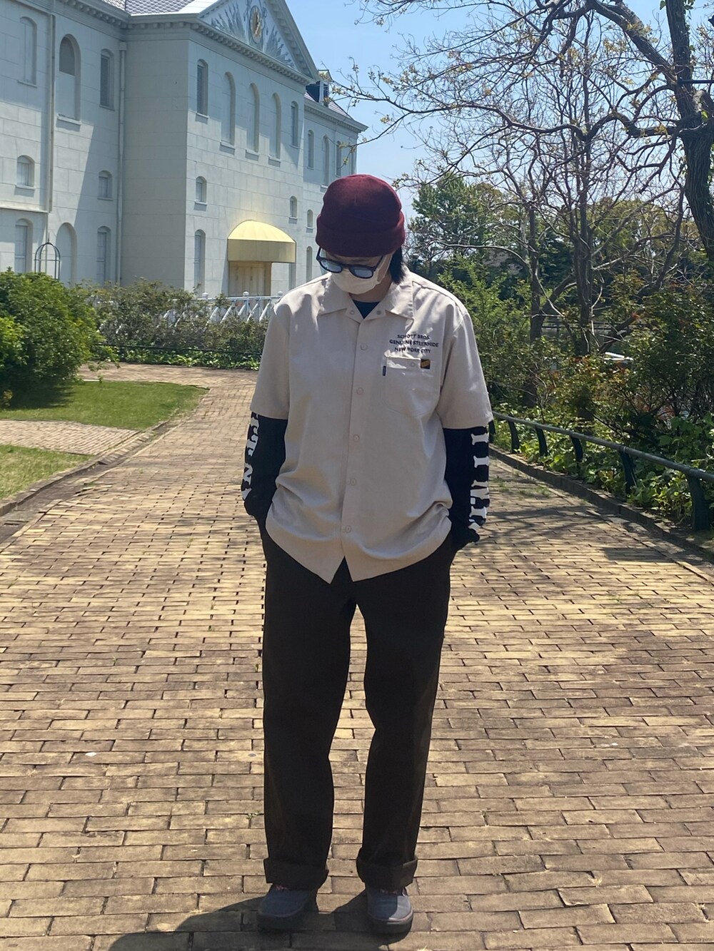 ホワイト系のシャツ/ブラウス、ブラック系のTシャツ/カットソー、ブラウン系のチノパンツを着用したレディースの春コーディネートの2枚目の写真