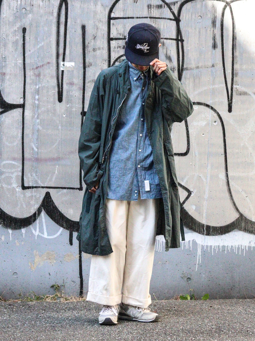 ブルー系のシャツ/ブラウス、グリーン系のモッズコート、ホワイト系のチノパンツを着用したメンズの冬コーディネートの2枚目の写真