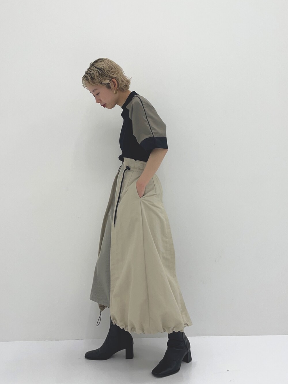 ベージュ系のスカート、ブラック系のTシャツ/カットソーを着用したレディースの春コーディネートの3枚目の写真