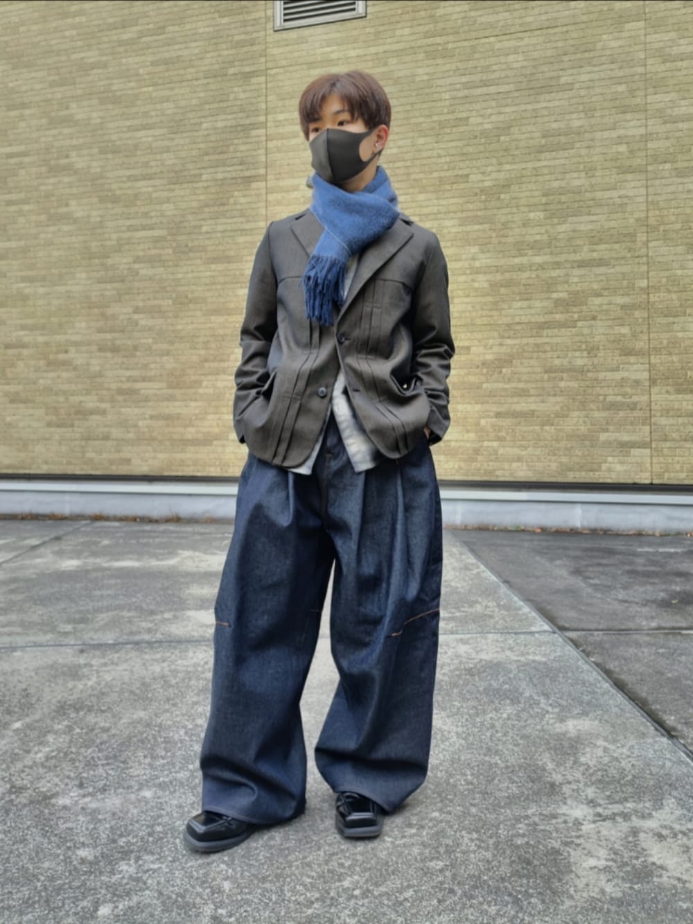 ブラウン系のテーラードジャケット、ブラック系のシャツ/ブラウス、ブルー系のデニムパンツを着用したメンズの冬コーディネートの2枚目の写真