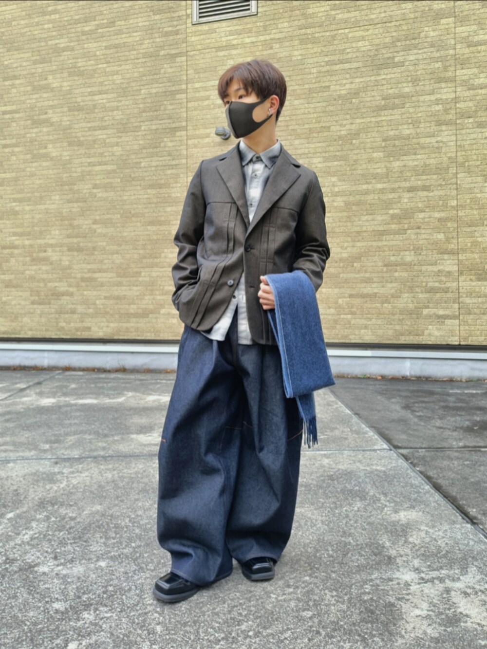 ブラウン系のテーラードジャケット、ブラック系のシャツ/ブラウス、ブルー系のデニムパンツを着用したメンズの冬コーディネートの4枚目の写真