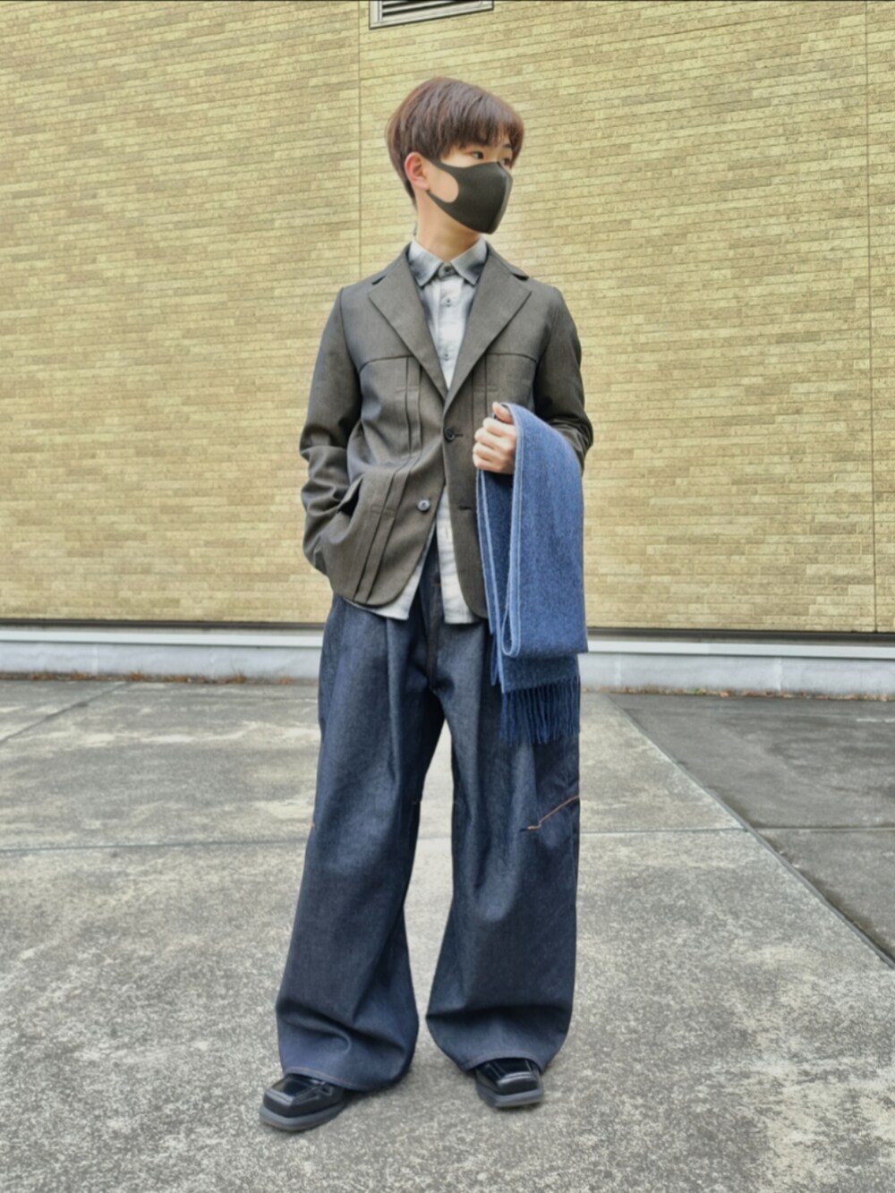 ブラウン系のテーラードジャケット、ブラック系のシャツ/ブラウス、ブルー系のデニムパンツを着用したメンズの冬コーディネートの3枚目の写真