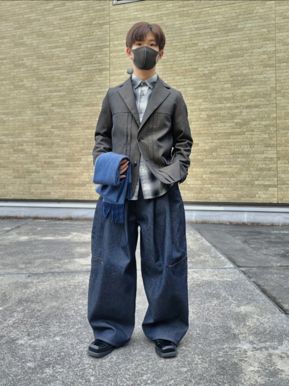 ブラウン系のテーラードジャケット、ブラック系のシャツ/ブラウス、ブルー系のデニムパンツを着用したメンズの冬コーディネートの5枚目の写真