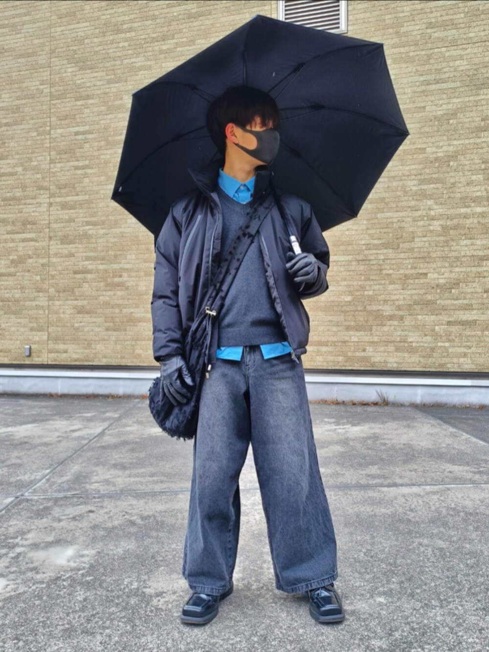 ブラック系のダウンジャケット/コート、ブラック系のニット/セーター、ブルー系のシャツ/ブラウスを着用したメンズの冬コーディネートの2枚目の写真