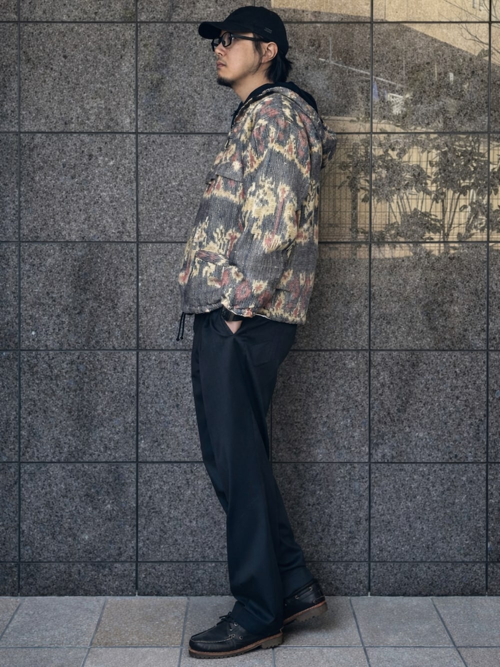 ベージュ系のマウンテンパーカー、グレー系のスラックス、ブラウン系のモカシン/デッキシューズを着用したメンズの冬コーディネートの2枚目の写真