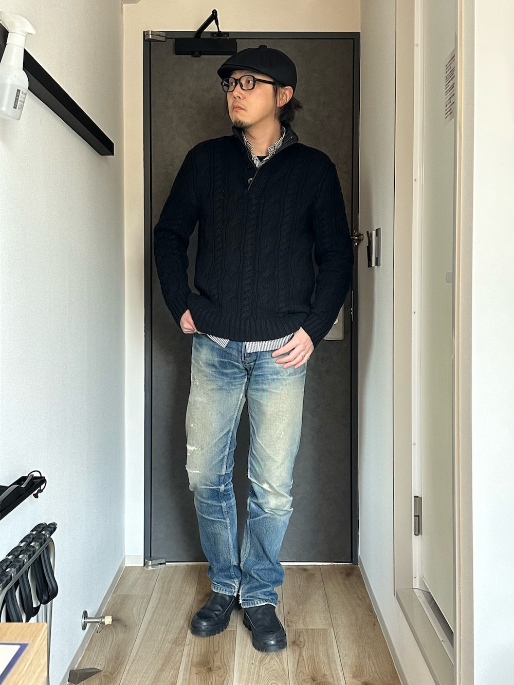 ブラウン系のステンカラーコート、ブラック系のニット/セーター、ブルー系のデニムパンツを着用したメンズの冬コーディネートの3枚目の写真