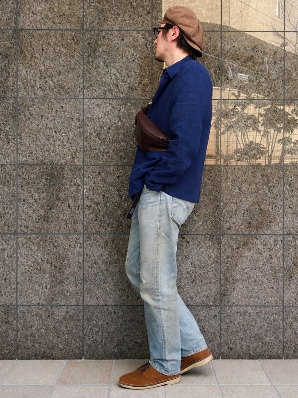 ブルー系のデニムパンツ、ブラウン系のブーツ、ブルー系のカバーオールを着用したメンズの春コーディネートの2枚目の写真
