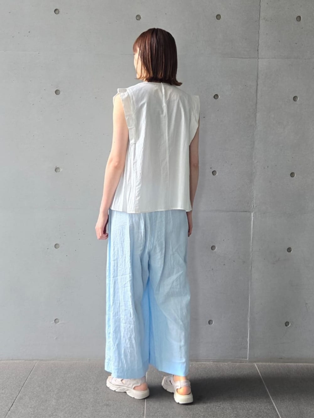 ホワイト系のシャツ/ブラウス、ブルー系のその他パンツ、グリーン系のネックレスを着用したレディースの夏コーディネートの3枚目の写真