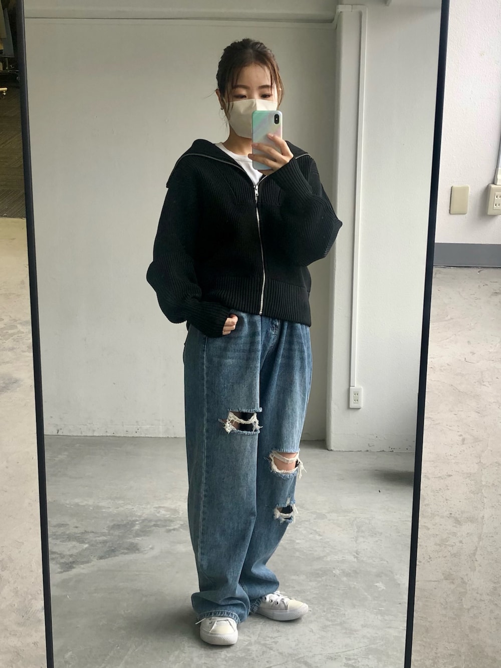 ブラック系のカーディガン/ボレロ、ブルー系のデニムパンツを着用したレディースの秋コーディネートの2枚目の写真