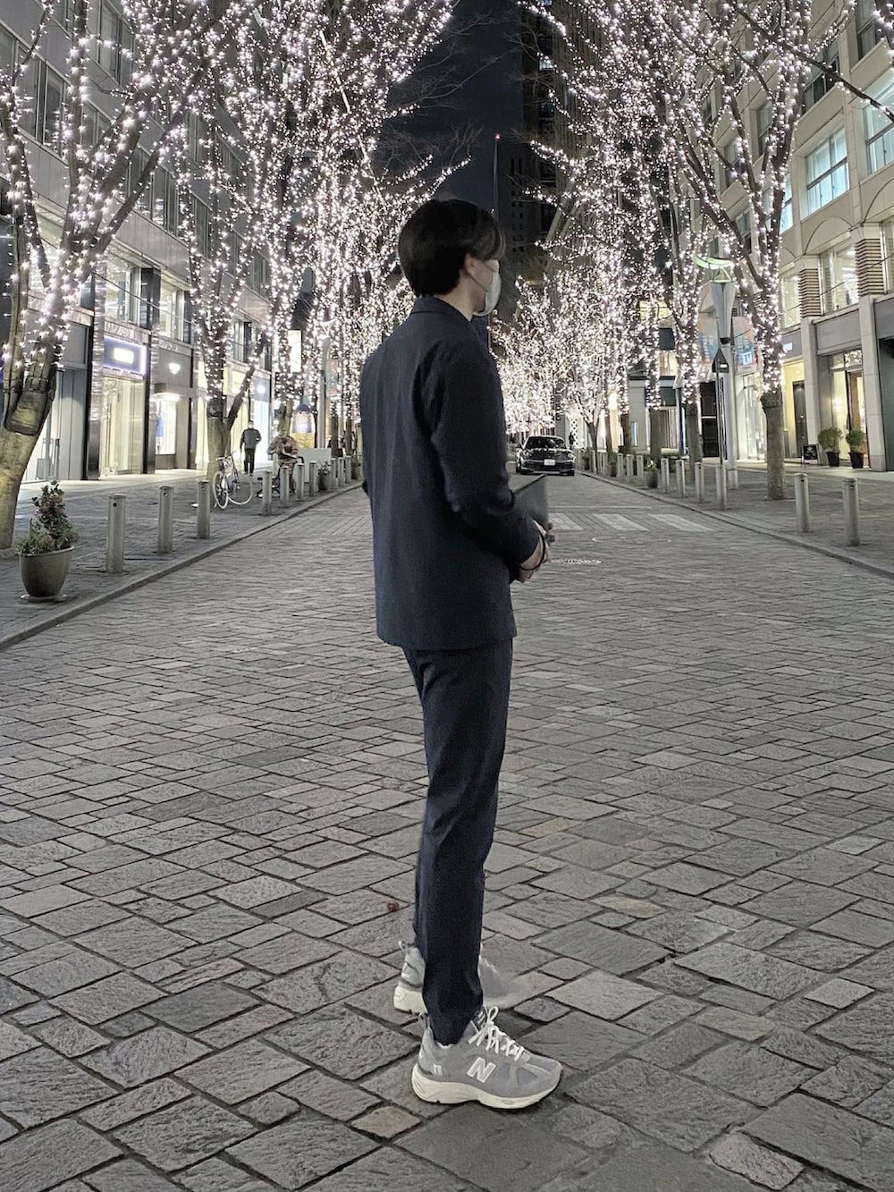 ブルー系のテーラードジャケット、ブラック系のクラッチバッグ、ブルー系のその他パンツを着用したメンズの春コーディネートの2枚目の写真