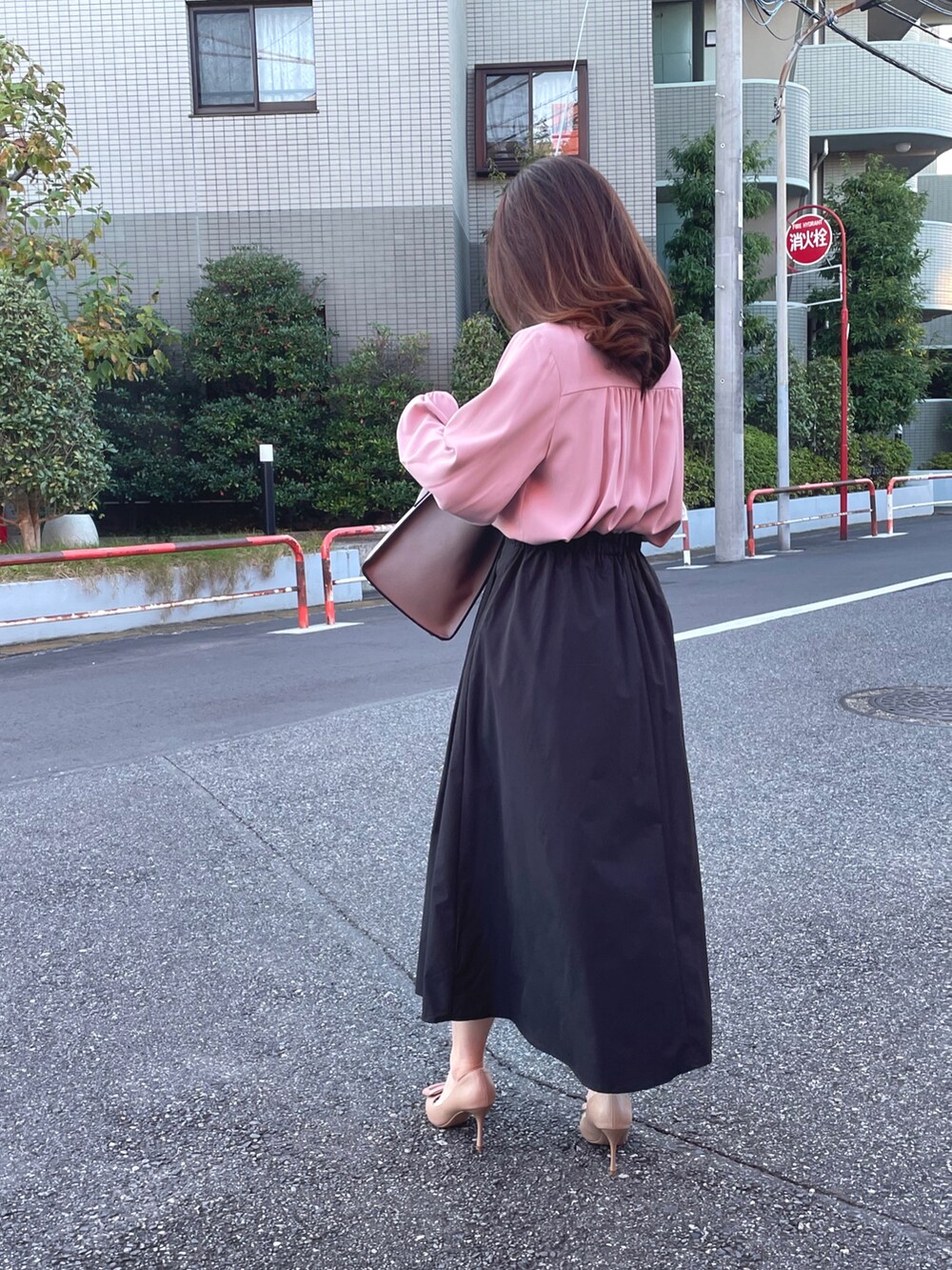 ピンク系のシャツ/ブラウス、ブラック系のスカートを着用したレディースの秋コーディネートの2枚目の写真