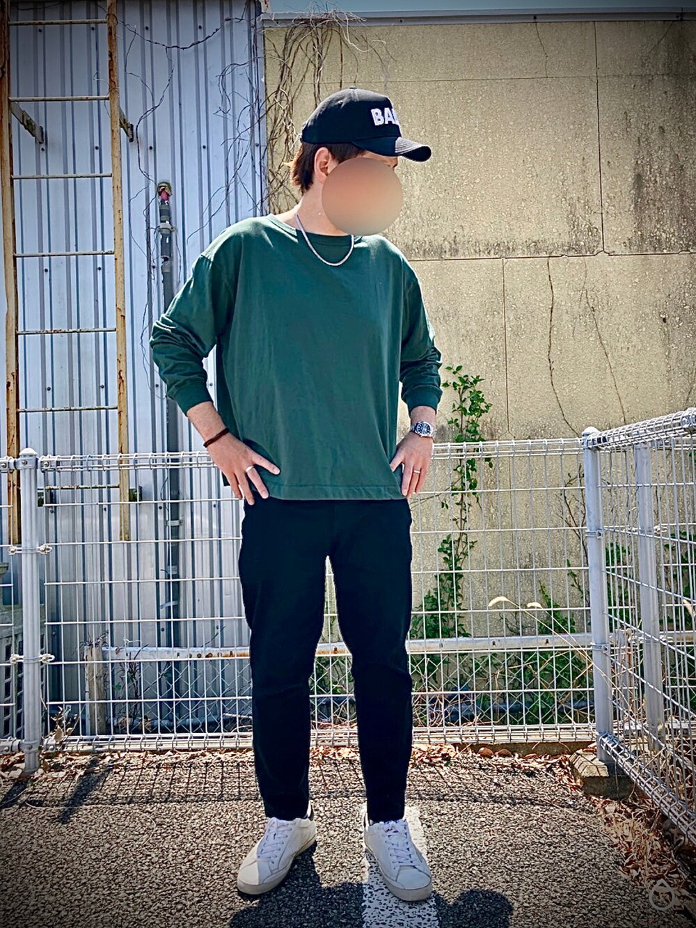 ホワイト系のスニーカー、グリーン系のTシャツ/カットソー、ブラック系のキャップを着用したメンズの春コーディネートの2枚目の写真