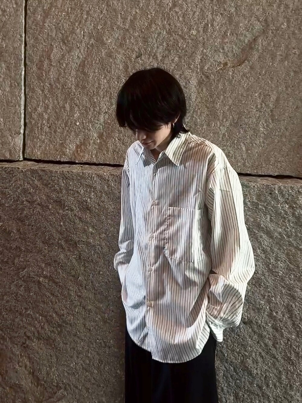 グレー系のシャツ/ブラウス、ブラック系のスラックス、ブラック系のブーツを着用したメンズの春コーディネートの4枚目の写真