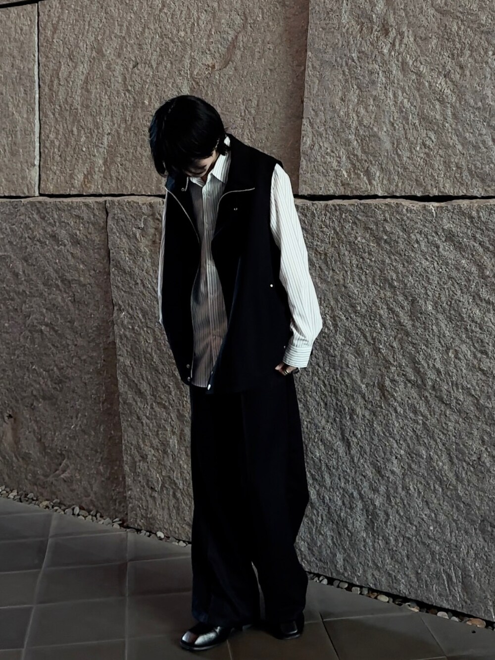 ブラック系のベスト、グレー系のシャツ/ブラウス、ブラック系のスラックスを着用したメンズの春コーディネートの2枚目の写真