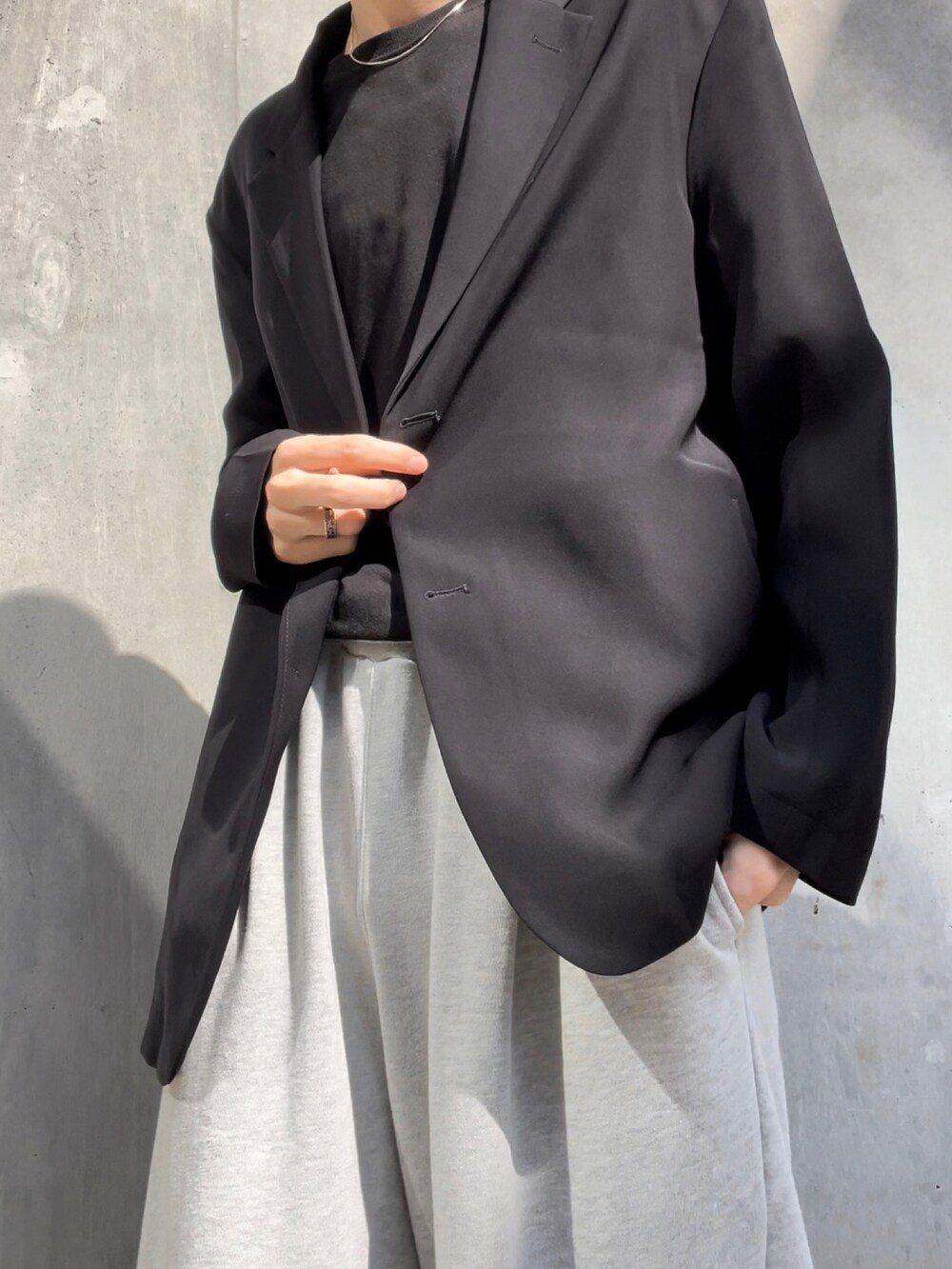 グレー系のスウェットパンツ、ブラック系のテーラードジャケット、ホワイト系のその他を着用したメンズの春コーディネートの2枚目の写真