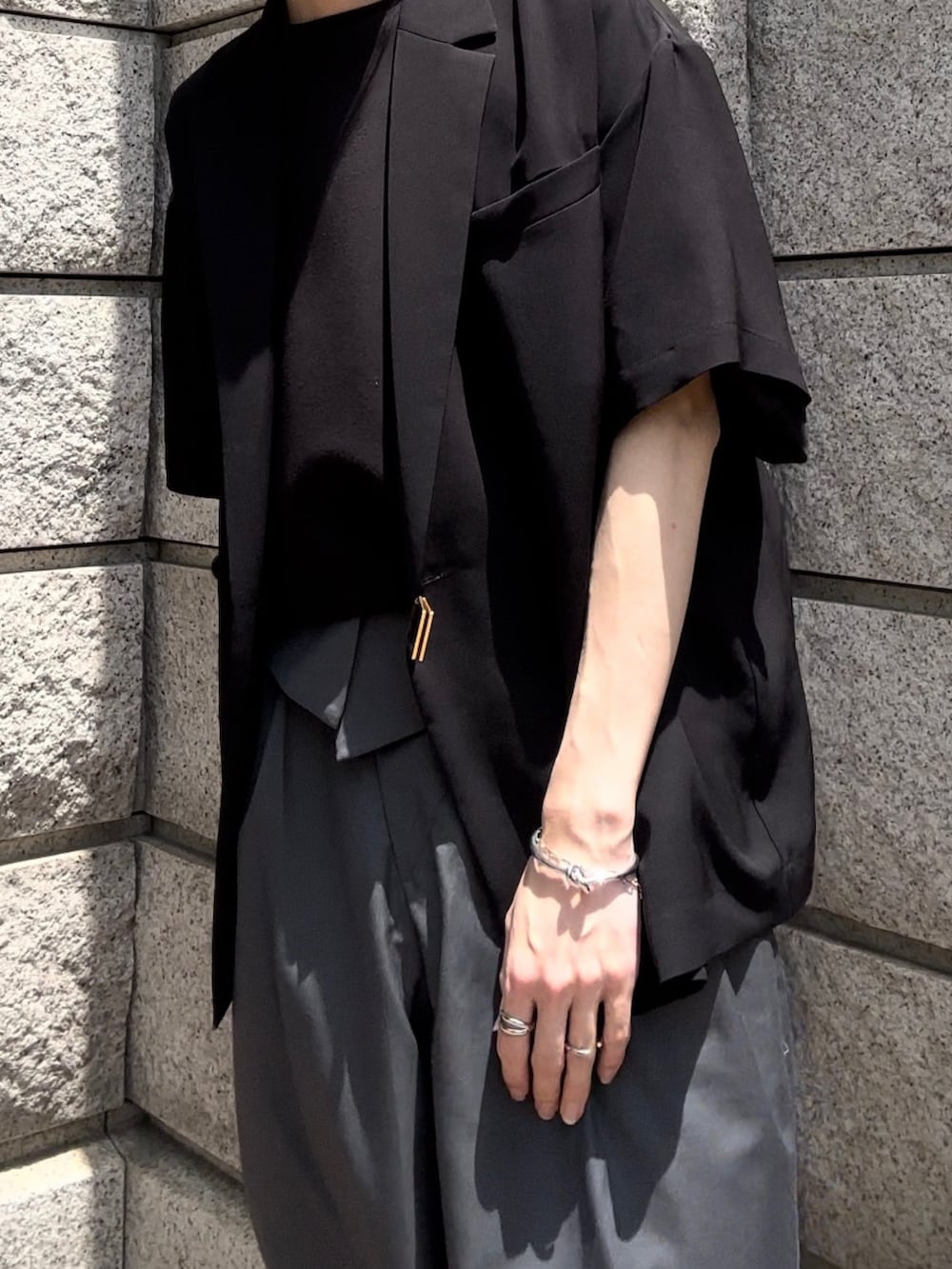 ブラック系のシャツ/ブラウス、グレー系のスラックス、ブラック系のブーツを着用したメンズの夏コーディネートの3枚目の写真