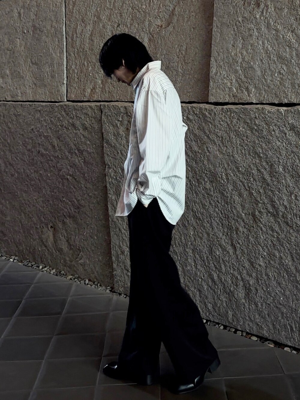 グレー系のシャツ/ブラウス、ブラック系のスラックス、ブラック系のブーツを着用したメンズの春コーディネートの3枚目の写真